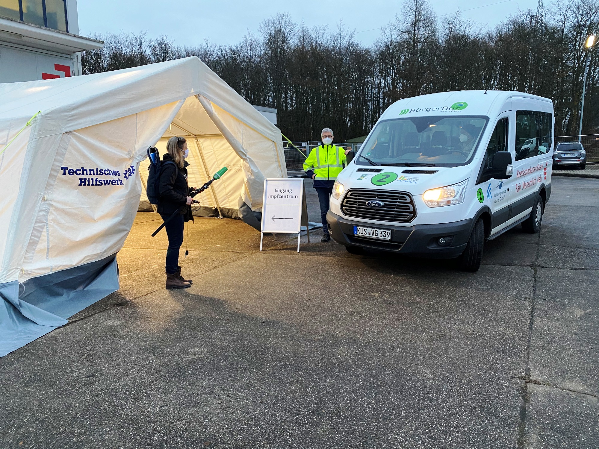 Der Bürgerbus aus der Verbandsgemeinde Oberes Glantal im Südkreis Kusel steht vor dem Impfzentrum in der ehemaligen Kaserne in Kusel auf dem Windhof. Am 7. Januar 2021, dem ersten Impftag, konnte der erste Fahrgast aus Waldmohr zur ersten Runde der Impfungen gefahren werden. Mit Interesse verfolgte eine Reporterin von Deutschlandradio die Aktion. Foto: Karl-Heinz Schoon/Bürgerbus Oberes Glantal